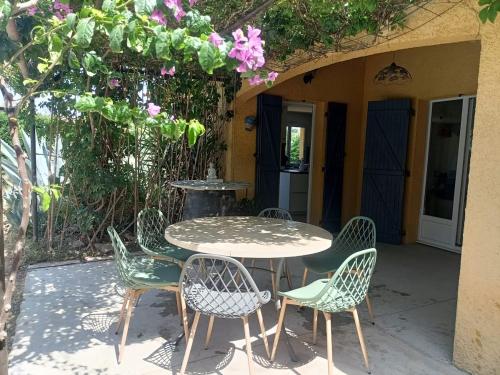 ein Tisch und Stühle auf einer Terrasse in der Unterkunft Villa climatisée avec grande piscine in Le Pouget