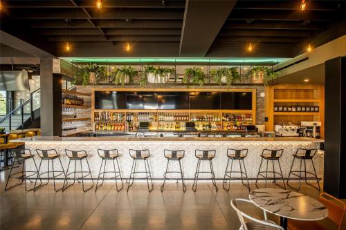 a bar in a restaurant with stools at The Lum Hotel Los Angeles Stadium District in Inglewood