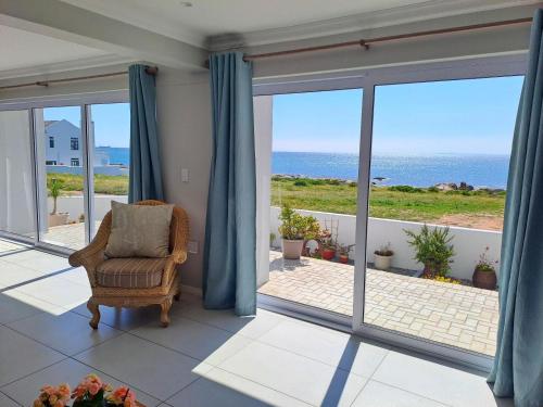 a room with a chair and a view of the ocean at West Coast Rock in St Helena Bay