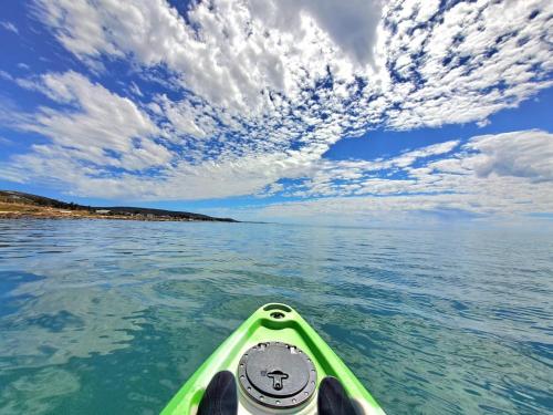 a green kayak in the water under a cloudy sky at West Coast Rock in St Helena Bay