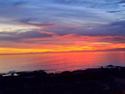a sunset over a body of water at West Coast Rock in St Helena Bay