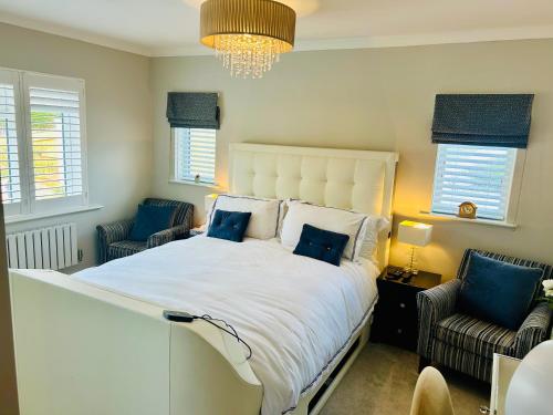 a bedroom with a large white bed with blue pillows at Wendys house in Sarisbury Green