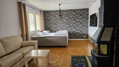 a living room with a couch and a bed at Large house with sauna, playground and close to the beach in Svanesund in Svanesund