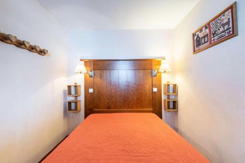 une chambre avec un lit avec une tête de lit en bois dans l'établissement Résidence Le Mont Soleil A - 3 Pièces 6 pers - LE MONT SOLEIL A - PLAGNE SOLEIL MAE-1634, à La Plagne Tarentaise