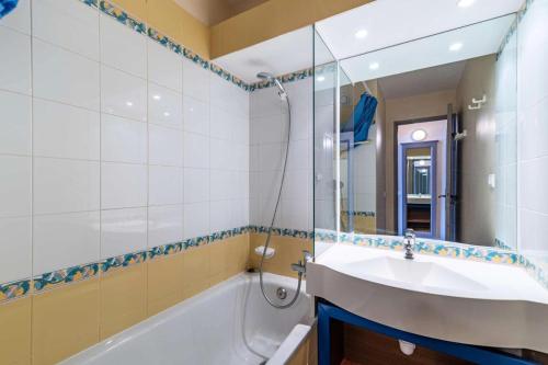 une salle de bain avec un lavabo, une baignoire et un miroir dans l'établissement Résidence Le Mont Soleil A - 3 Pièces 6 pers - LE MONT SOLEIL A - PLAGNE SOLEIL MAE-1634, à La Plagne Tarentaise