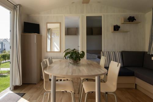 a dining room and living room with a table and chairs at Vakantiepark Klein Strand - Comfort Chalet 4p in Jabbeke