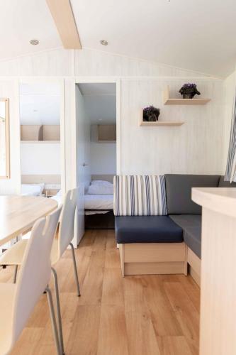 a living room with a couch and a table at Vakantiepark Klein Strand - Comfort Chalet 4p in Jabbeke