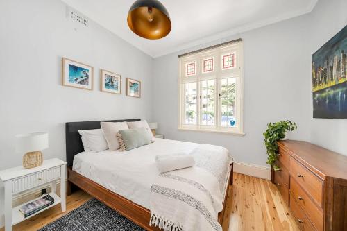 Un dormitorio con una cama y una cómoda y una ventana. en Marvelous Manly Home moments from the Beach - NEW, en Sídney
