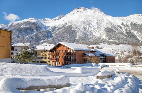 a city covered in snow with a mountain in the background at Balcons B 024 - PARC NAT VANOISE appart 6 pers in Val Cenis