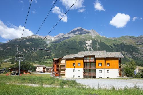 a building with a mountain in the background at Balcons B 024 - PARC NAT VANOISE appart 6 pers in Val Cenis