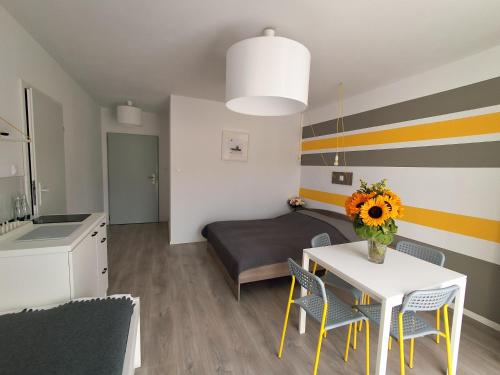 a room with a table and a bed and a kitchen at Ludna 27 in Niechorze