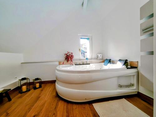 Cette chambre dispose de parquet et d'une grande baignoire blanche. dans l'établissement Faillot - Séjour à Auxerre, à Auxerre