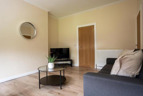 a living room with a couch and a table at Curtis Apartment in Glasgow