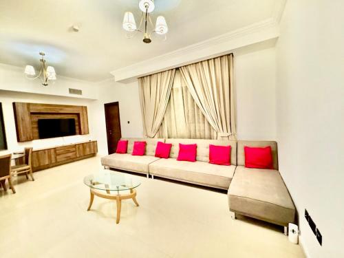 a living room with a couch and red pillows at JSCOM GRAND Residence in Dubai