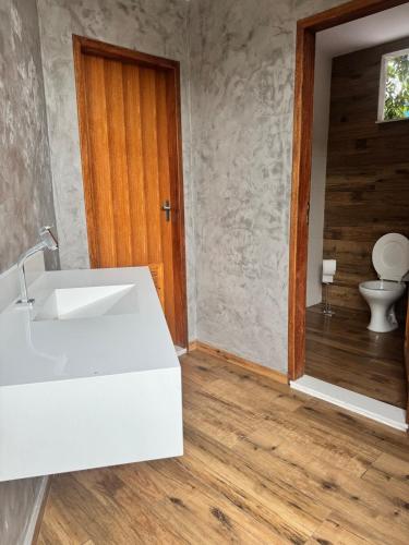 a bathroom with a white sink and a toilet at Home in Guapimirim for Family in Guapimirim