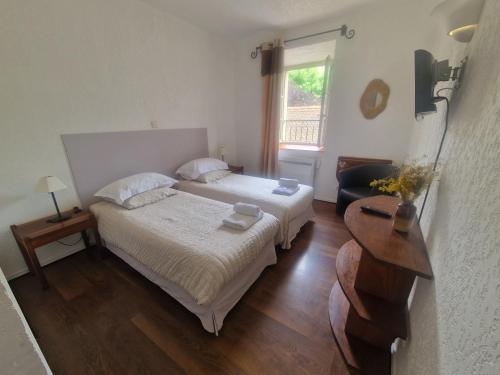 a bedroom with two beds and a table and a window at L'Auberge de Mens in Mens