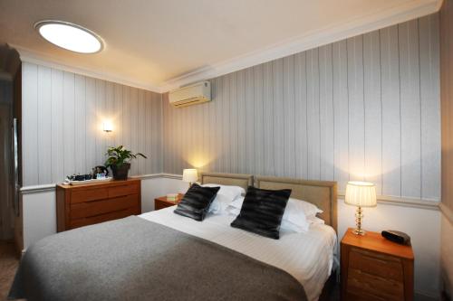 a bedroom with a bed with two black pillows at Watersmeet Hotel in Woolacombe