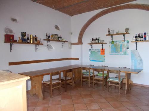 een keuken met twee houten tafels en stoelen bij Agriturismo Contessa Beatrice in San Vincenzo