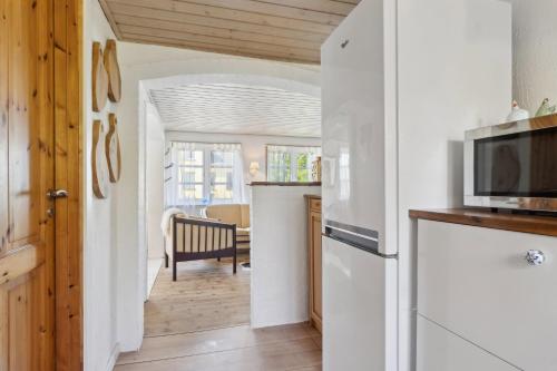 a kitchen with a refrigerator and a dining room at The Cozy Cottage in Hirtshals