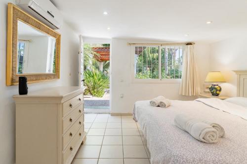 Un dormitorio con una cama con espejo y una cómoda. en Lovely Villa Las Palmeras, en Marbella