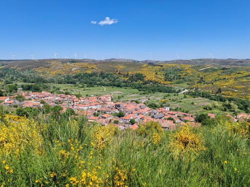 an airplane flying over a town in a valley at Quintinha dos Emigrantes in Cujó
