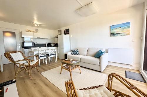 a living room with a couch and a table at Vue mer 180 - Charmant T3 - Coup de coeur garanti in Ploemeur
