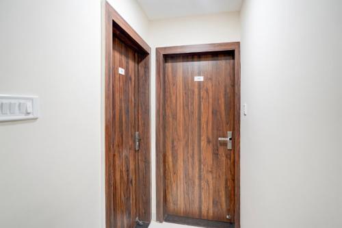 a pair of wooden doors in a room at Hotel O Lakshya in Indore