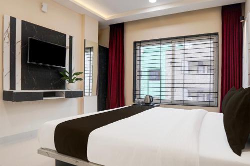 a bedroom with a large bed and a large window at Hotel O Lakshya in Indore