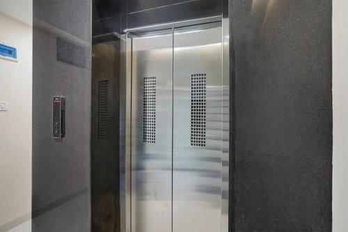 a shower with a glass door in a bathroom at Hotel O Lakshya in Indore