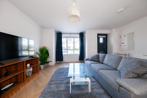 a living room with a couch and a flat screen tv at Modern 2 bed house in Hollystown with free parking in Dublin