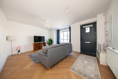 a living room with a couch and a television at Modern 2 bed house in Hollystown with free parking in Dublin