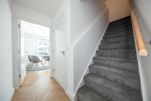 a staircase in a home with white walls and gray stairs at Modern 2 bed house in Hollystown with free parking in Dublin