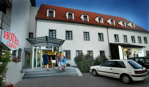 
a person sitting on a bench in front of a building at Gasthof Lerner in Freising
