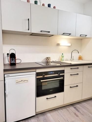 une cuisine avec des armoires blanches et un four à plaques de cuisson dans l'établissement 21m With Wifi In The Center And Near The Beach, à Bandol