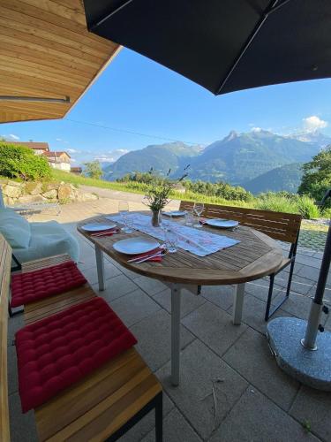 a wooden table and chairs with a view of mountains at Haus Zimba Ferienwohnung am Bartholomäberg in Bartholomäberg