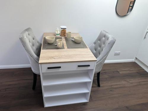 a table with two chairs with cups and mugs on it at Little side house in Cambridge in Trumpington