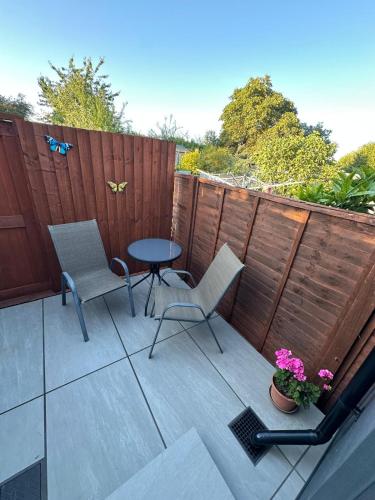a patio with a table and chairs and a fence at Little side house in Cambridge in Trumpington