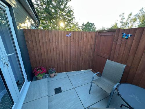 a patio with two chairs and a table and a fence at Little side house in Cambridge in Trumpington