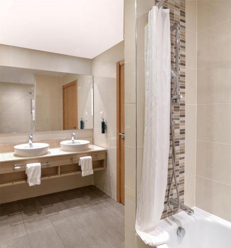 a bathroom with two sinks and a shower at Hilton Garden Inn Tanger City Center in Tangier