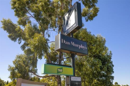 a street sign with a clock on a pole at Nightcap at Macquarie Inn in Dubbo