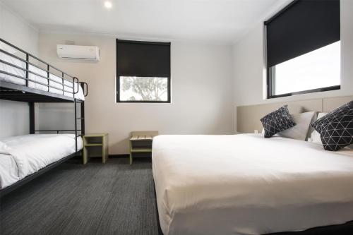 a bedroom with two beds and a bunk bed at Nightcap at St Albans Hotel in St Albans