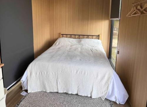 ein Schlafzimmer mit einem Bett mit einer weißen Bettdecke in der Unterkunft A Kuei Cottage X by Tiny Away in Wufeng