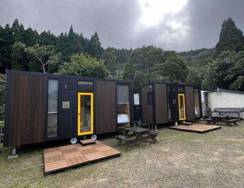 eine Reihe von Schiffscontainern, die auf einem Feld geparkt sind in der Unterkunft A Kuei Cottage X by Tiny Away in Wufeng