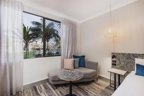 a living room with a chair and a window at Nightelier Mermaid Waters in Gold Coast