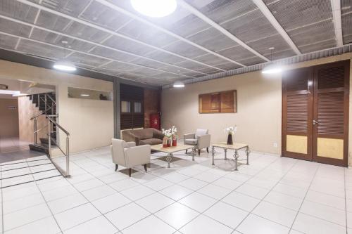 a lobby with a waiting room with chairs and tables at Amuarama Hotel in Fortaleza
