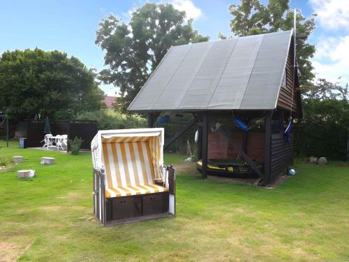 a chair sitting in a yard next to a gazebo at Apartment Altenkirchen 4 in Altenkirchen