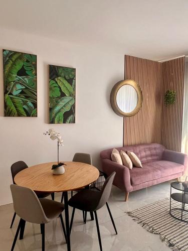 a living room with a table and a pink couch at Stylish 2-bedroom Apartment- near Valletta! Great for families or groups in Gwardamanġa
