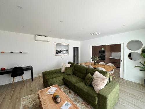a living room with a green couch and a table at The Olive Tree Apartment in Tavira