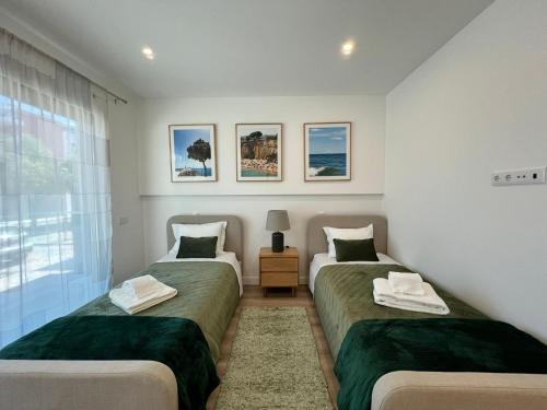 a bedroom with two beds and a window at The Olive Tree Apartment in Tavira