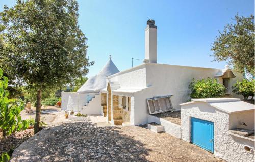 a white house with a blue door and trees at Cozy Home In Ostuni With Wifi in Ostuni